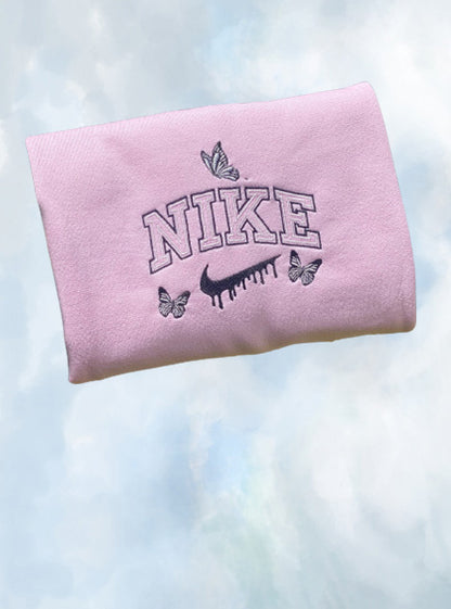 The butterfly drip nike crewneck in light pink with black outline embroidery.