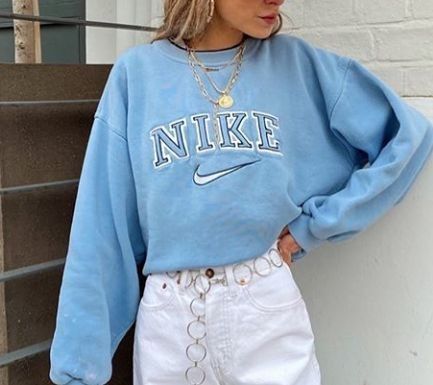 Stylish girl wearing the embroidered light blue nike swoosh crewneck and a stylish white skirt.