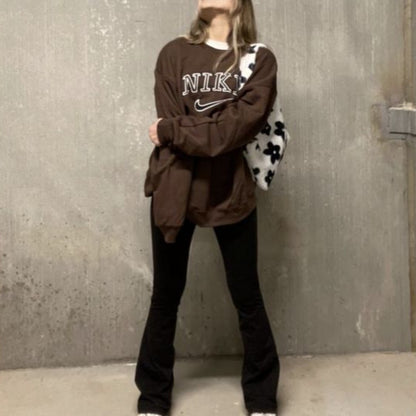 Girl posing in the dark brown nike swoosh embroidered crewneck.