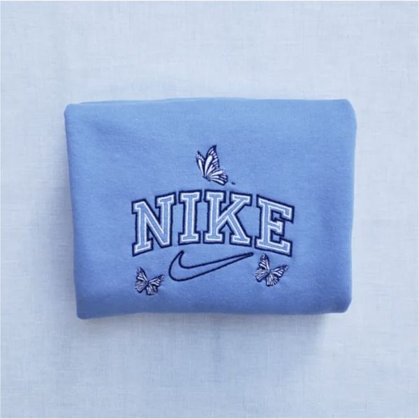 The butterfly outline nike crewneck in light blue with dark blue and white outline embroidery.