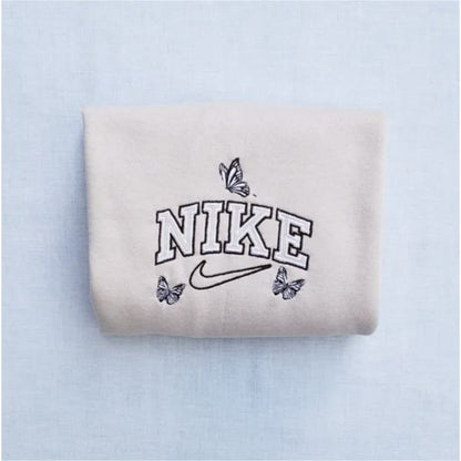 The butterfly outline nike crewneck in sand with black and white outline embroidery.