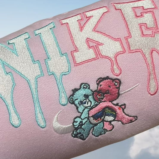 The care bears nike swoosh embroidered crewneck in light pink.