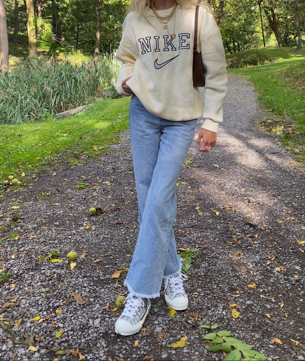 Girl posing in the trendy nike swoosh embroidered crewneck.