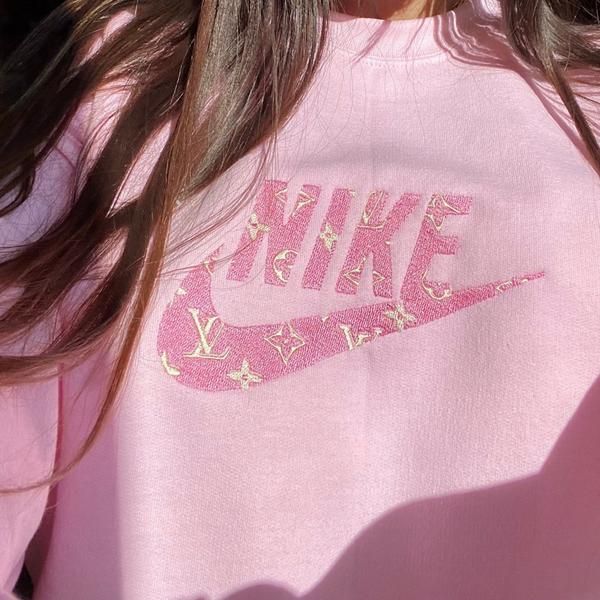 Girl wearing the light pink LV Nike embroidered sweatshirt with light pink and beige embroidery.