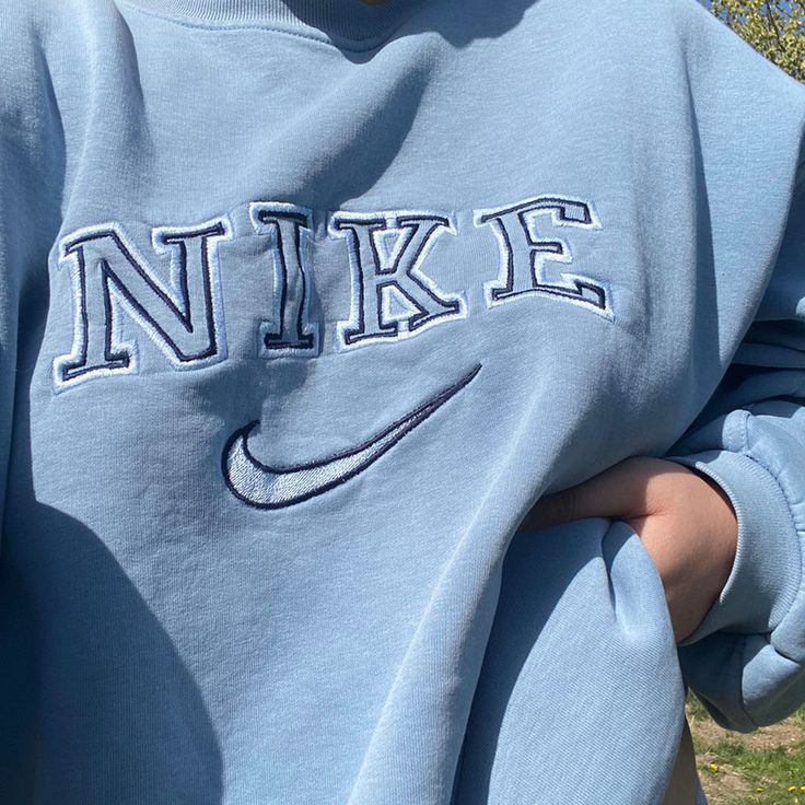 Girl wearing the light blue swoosh nike embroidered crewneck.