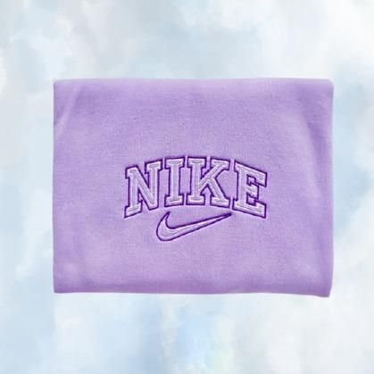 The light purple Nike embroidered crewneck sweatshirt with dark purple embroidery.