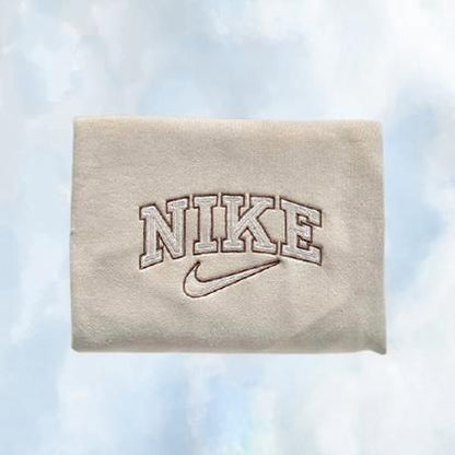 The beige Nike swoosh embroidered crewneck with brown embroidery.