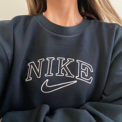 Girl wearing the oversized vintage embroidered Nike crewneck in black with white embroidery.