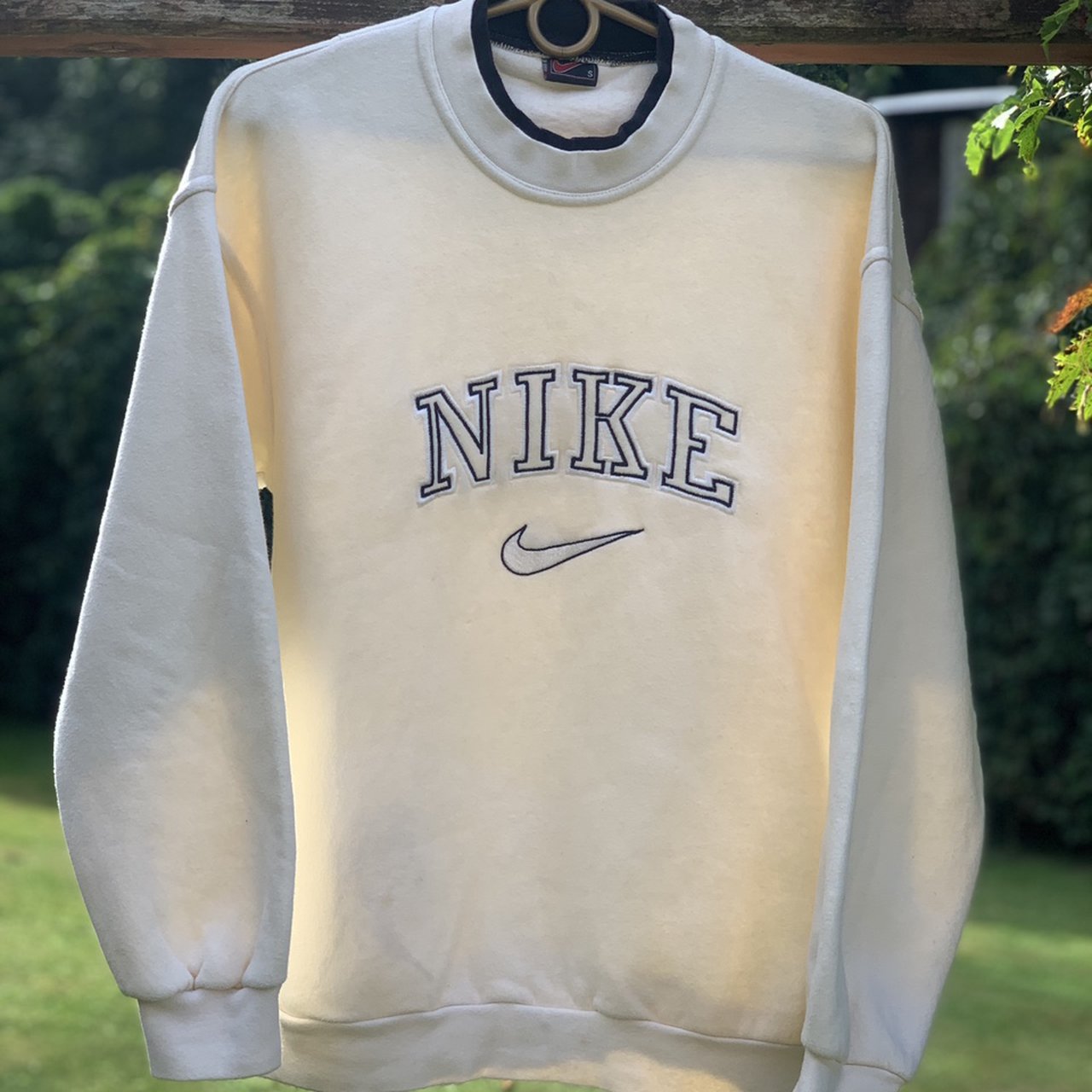 Layout of the beige nike swoosh embroidered crewneck.