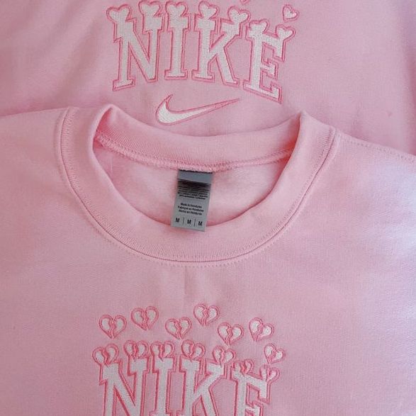 Aesthetic close up of the Nike Valentine Hearts Embroidered crewneck in light pink.