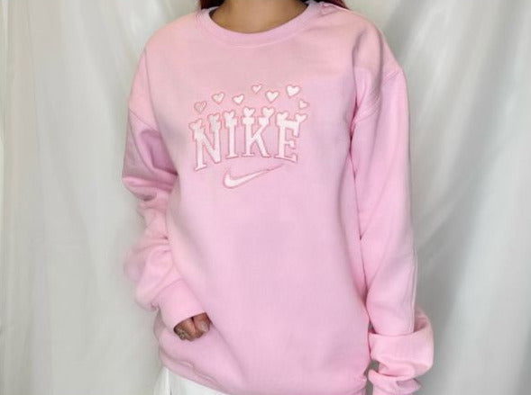 Girl wearing the light pink Nike Valentine Hearts embroidered sweatshirt.