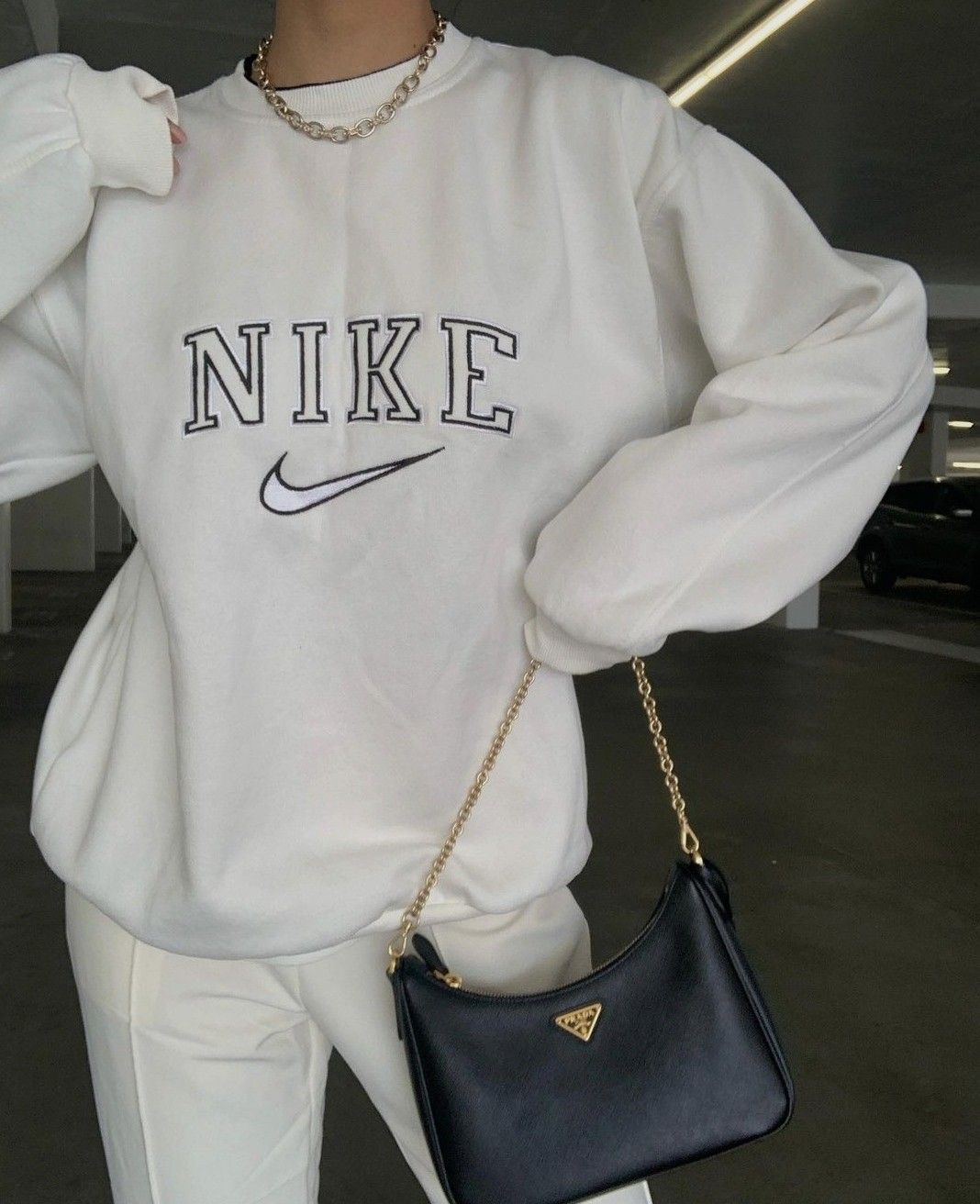 Girl posing in the trendy white nike swoosh embroidered crewneck.