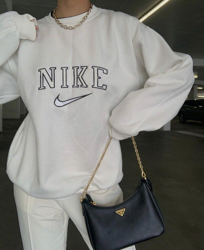 Girl posing in the trendy white nike swoosh embroidered crewneck.