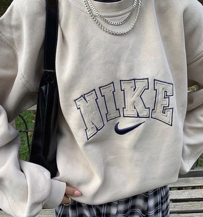 The Nike spellout embroidery crewneck in light beige.