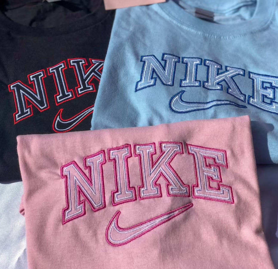 Group layout of the nike vintage embroidered t-shirts in black, blue, and pink.